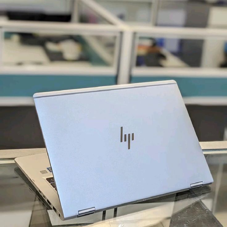 HP EliteBook partially open side angle view on glass surface