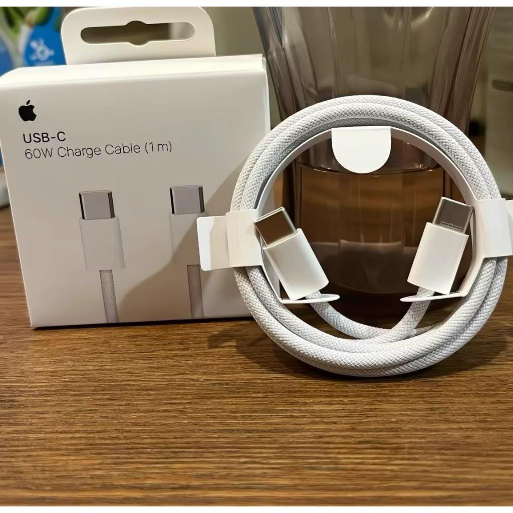 Apple USB-C 60W Charge Cable 1m braided white cable unboxed coiled in front of original box on wooden surface