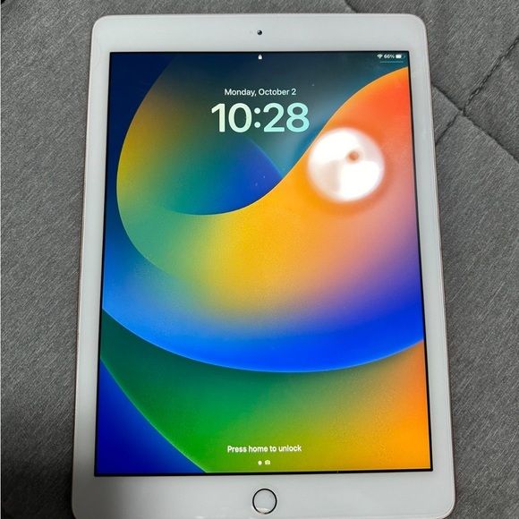 Apple iPad 6th Generation Silver front view showing iOS 16 colorful lock screen with home button