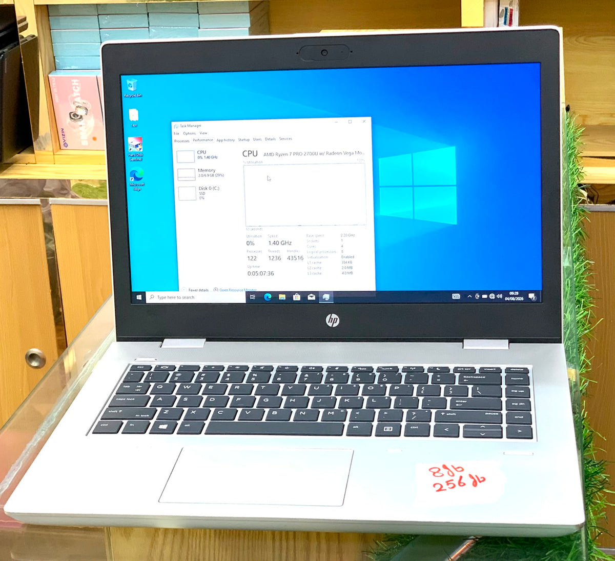 HP EliteBook open showing AMD Ryzen 7 PRO specs in Task Manager on Windows 10
