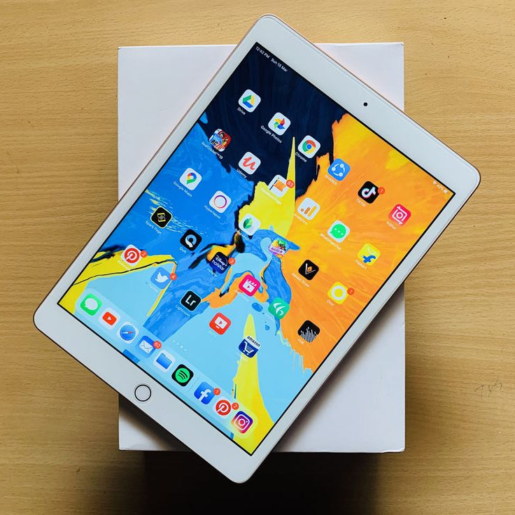 Apple iPad 7th Generation Silver front view showing colorful iOS home screen with apps on original white box