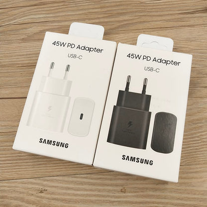 Samsung 45W PD USB-C adapter white and black original retail boxes side by side on wooden surface