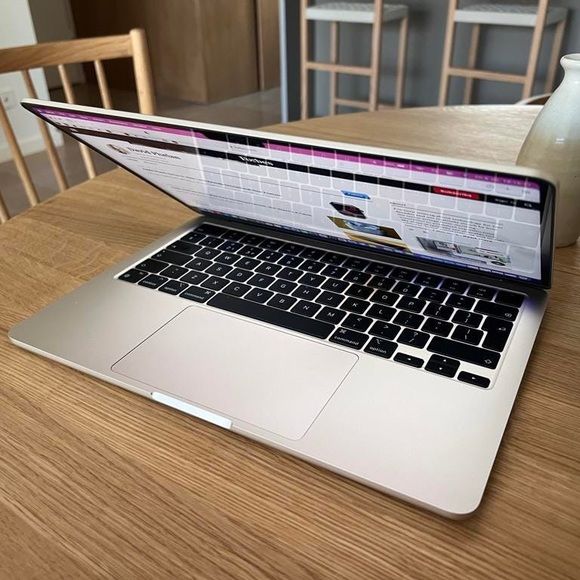 MacBook Pro M1 open showing macOS with lake wallpaper