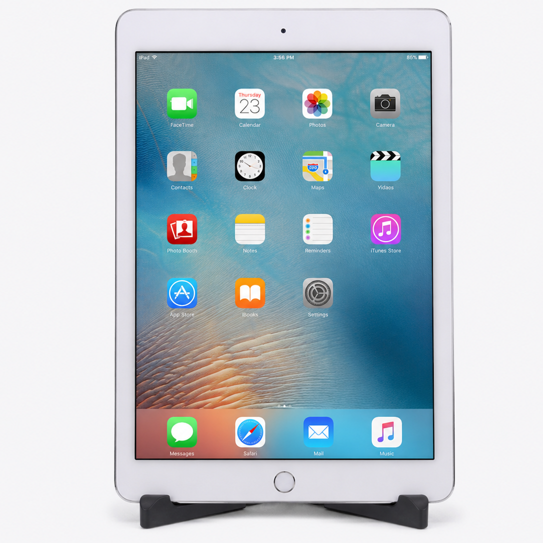 Apple iPad Pro 9.7-inch Silver front view showing iOS home screen with apps on tablet stand