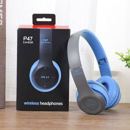 P47 wireless Bluetooth headphones blue and gray color with original black box on wooden surface with plant in background