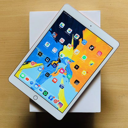 Apple iPad 7th Generation Silver front view showing colorful iOS home screen with apps on original white box